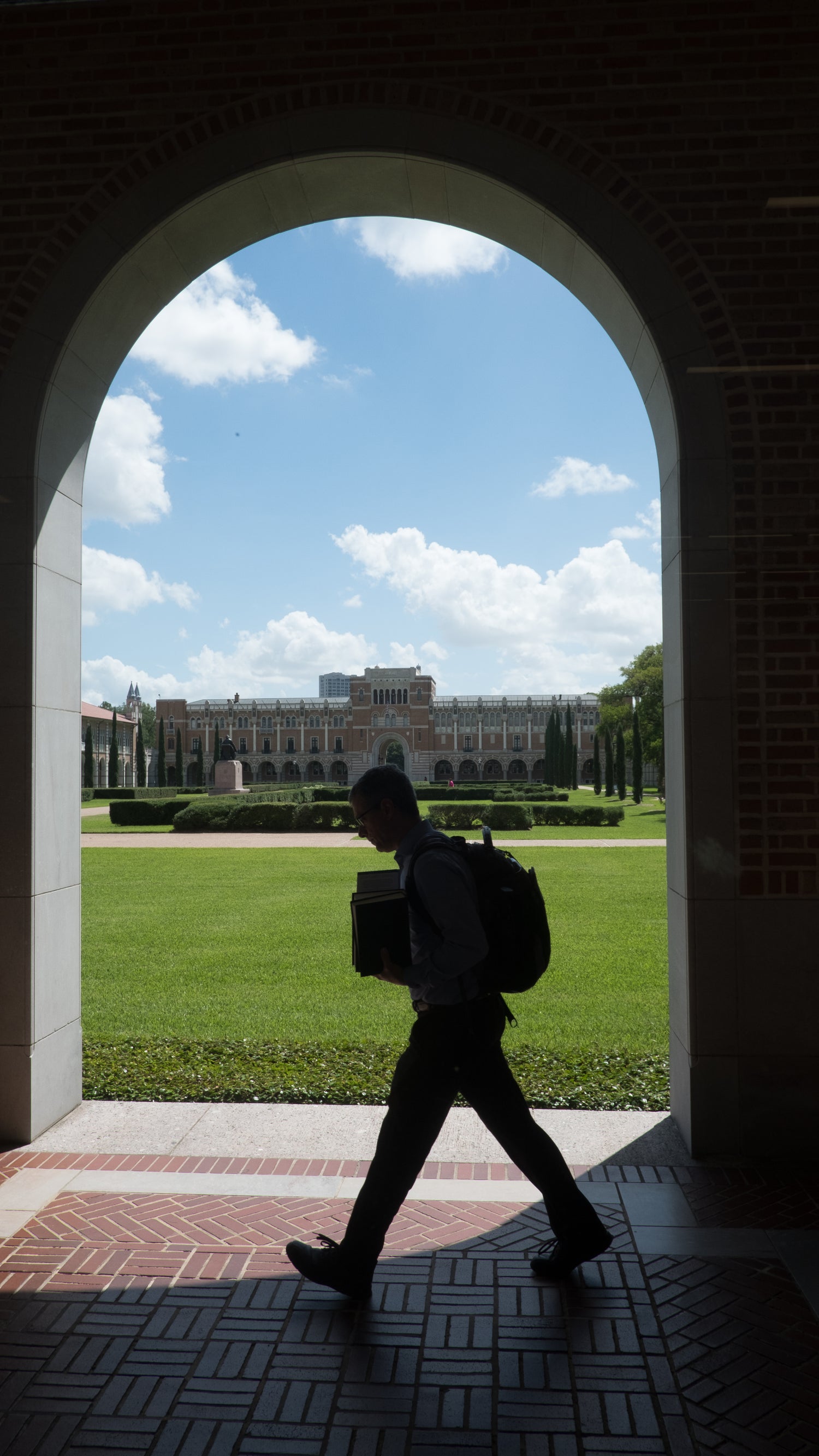 Student walking under an archway.