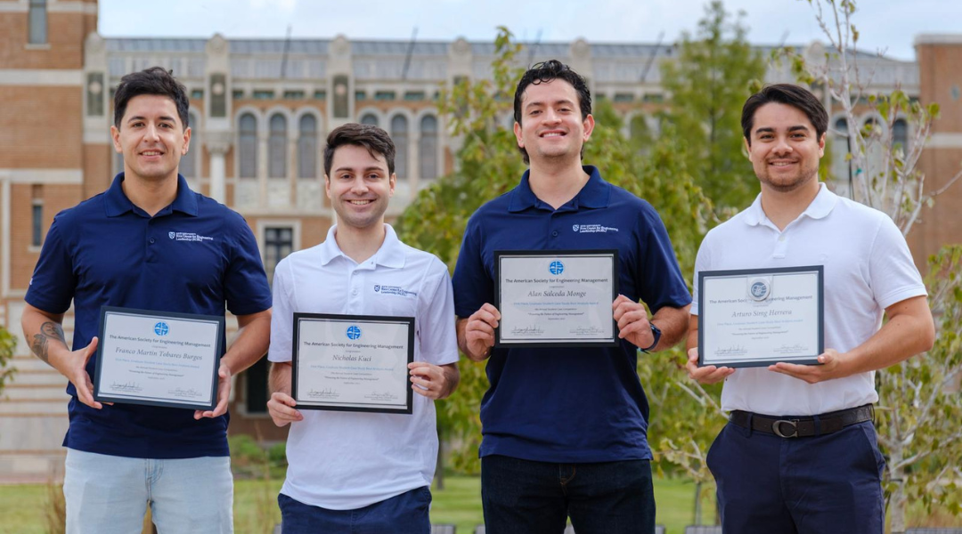 Graduate student pose in the quad with their awards