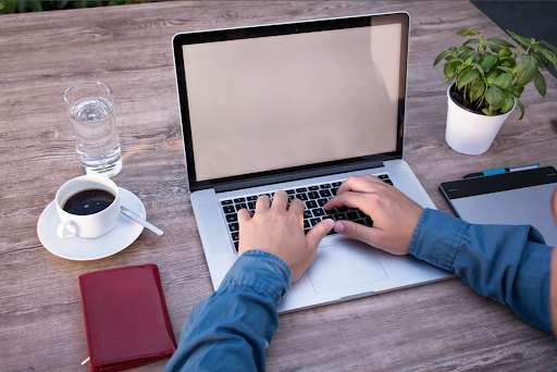 computer typing with a cup of coffee