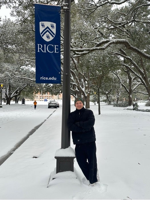 Nathaniel near a Rice campus sign