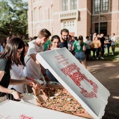 Grad students eat pizza in the graduate commons outside Valhalla