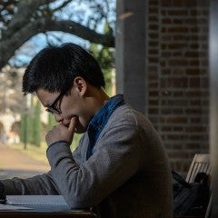 Student in Fondren Library studies his computer screen