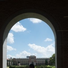 Student walking under an archway.