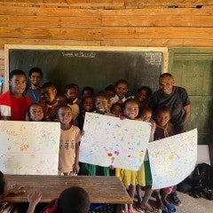 Students holding up their drawings. 