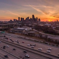 Downtown Houston with I-59 in the foreground. It is sunset.