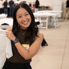 A Fulbright student from Japan holds up a Rice Fulbright t-shirt