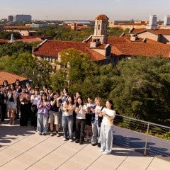South Korean undegraduates pose for a photo with the Rice campus in the background