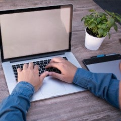 computer typing with a cup of coffee