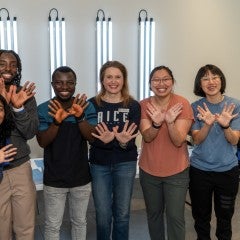 Rice graduate students with rice owls pose 