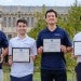 Graduate student pose in the quad with their awards