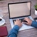 computer typing with a cup of coffee
