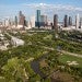 An aerial photo of Buffalo Bayou with the skyline of Downtown Houston in background